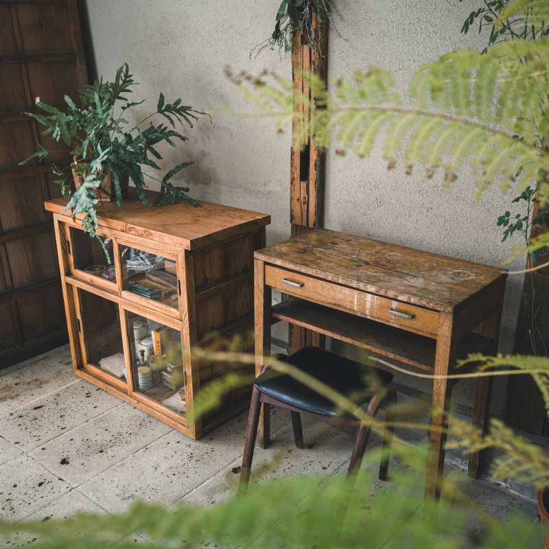 Covered patio with rustic wooden cabinets, writing desk, and stool